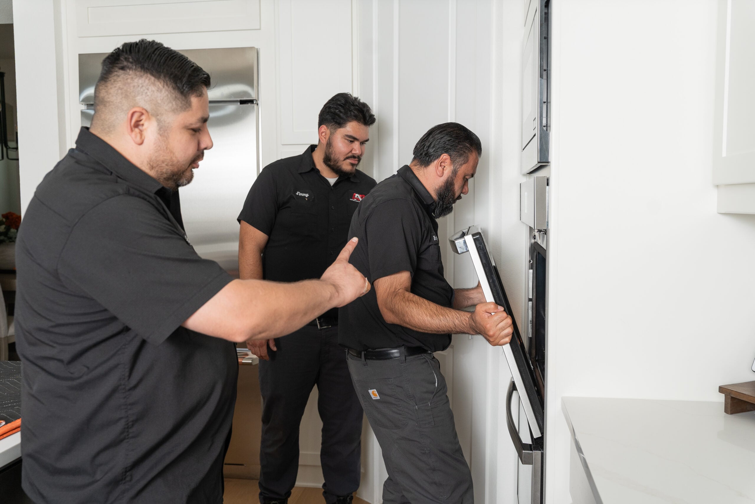 Action Appliance Repair technicians diagnosing a wall oven
