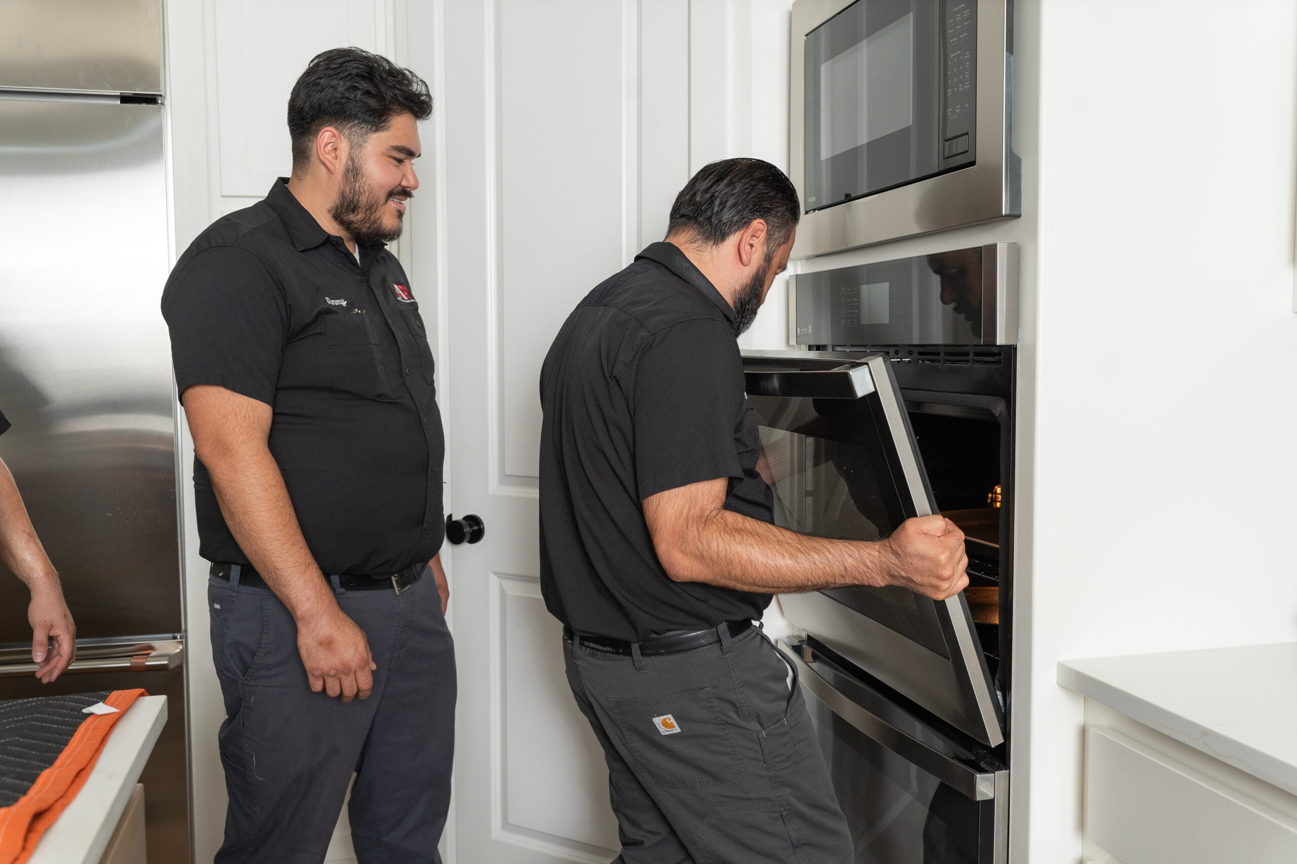 Technician removing a wall oven door for repair