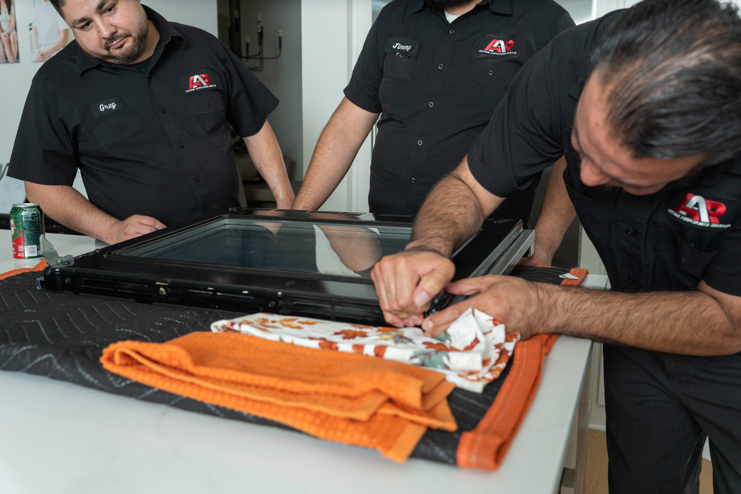 Technicians removing an oven door glass panel