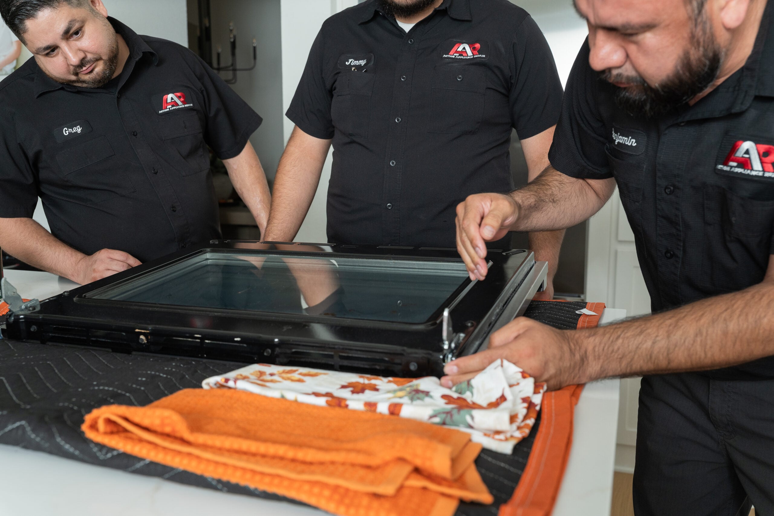 Technician cleaning an oven door glass during service