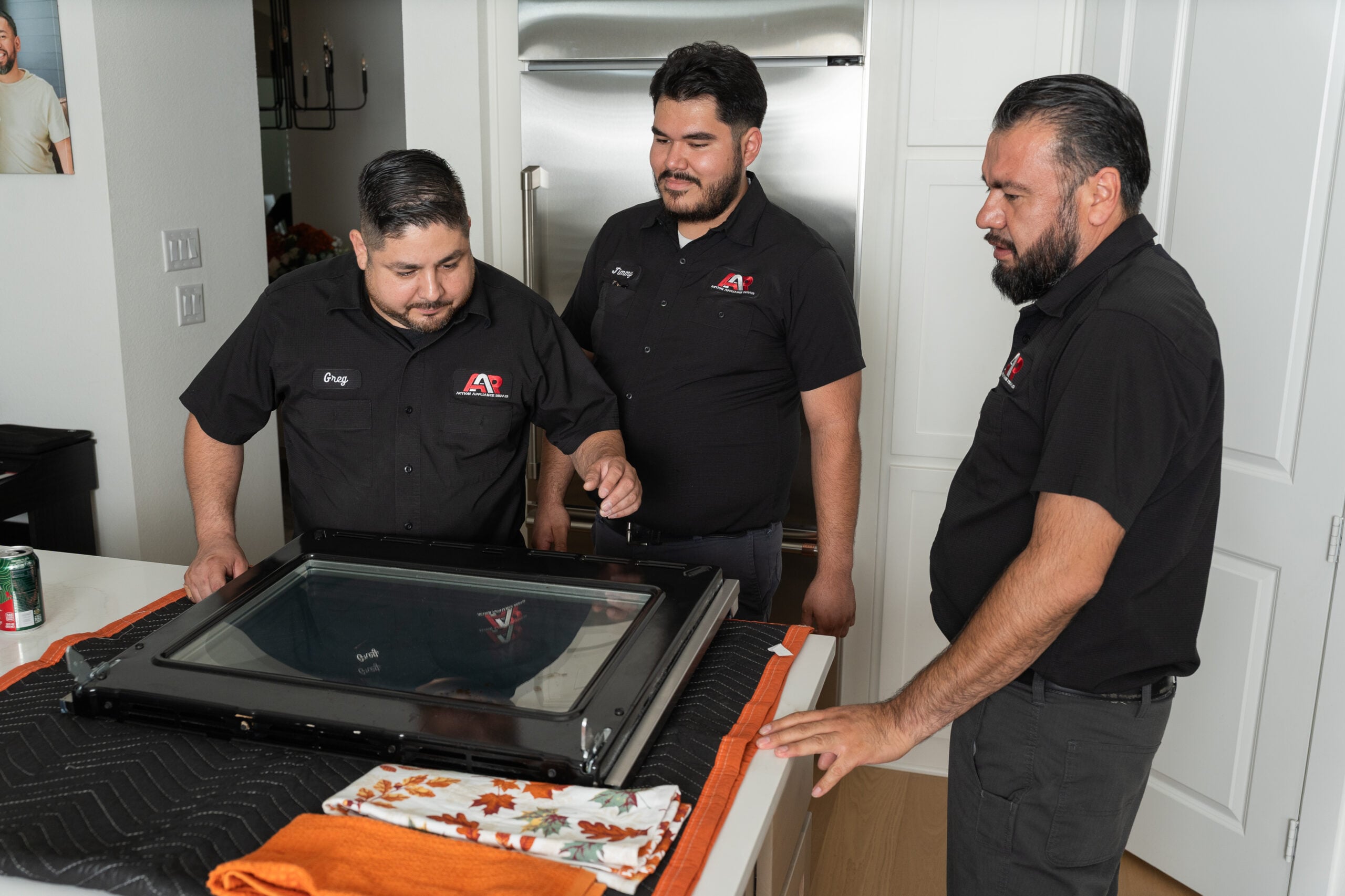 Action Appliance Repair technicians repairing an oven