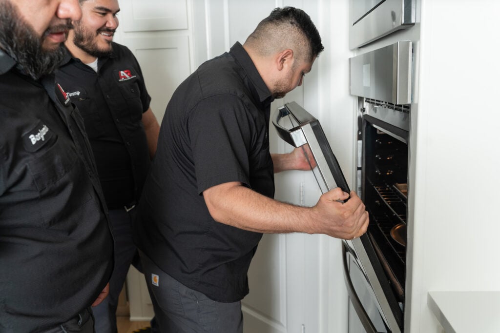 Technician repairing a built-in wall oven