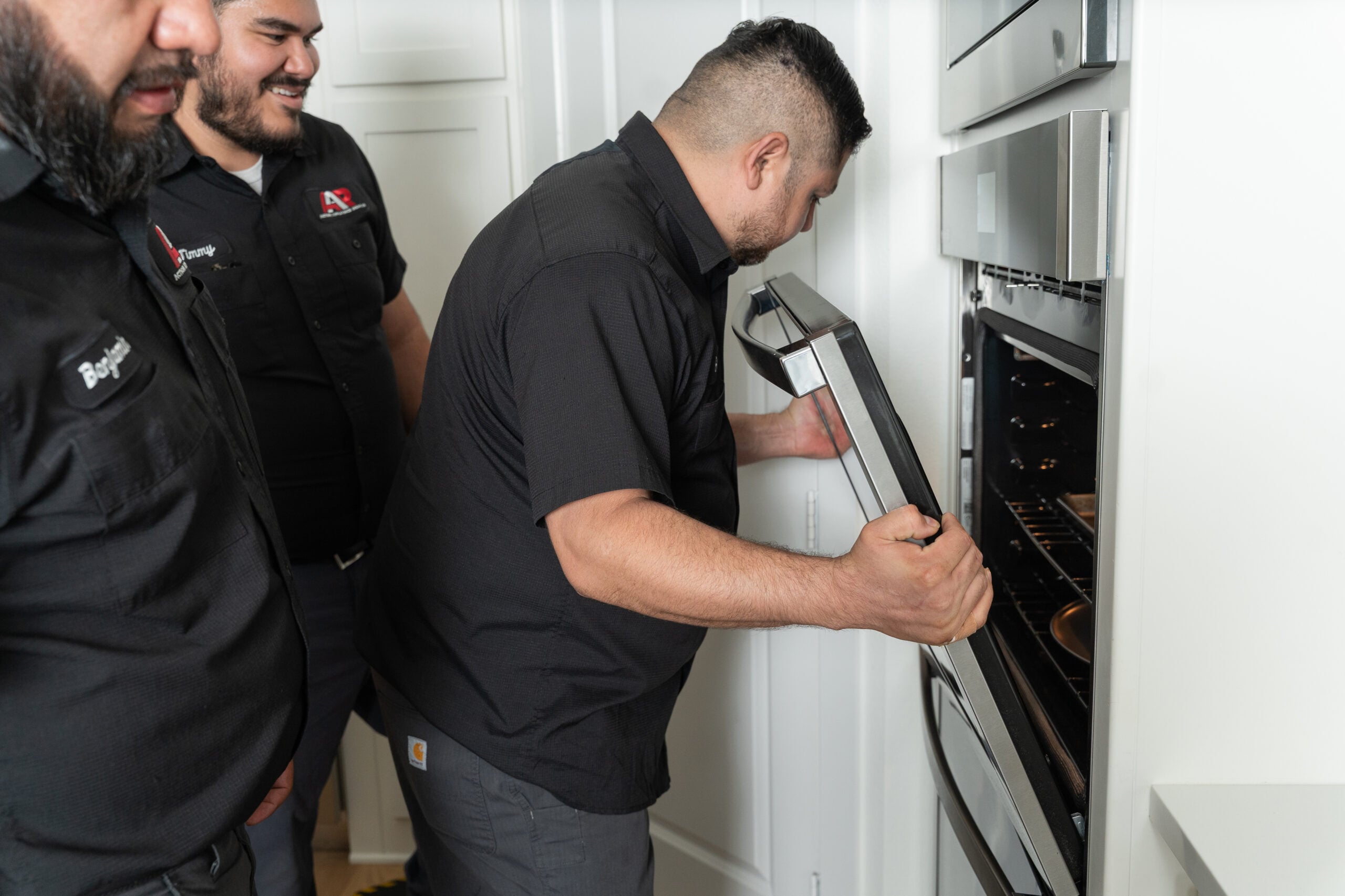 Technician repairing a built-in wall oven
