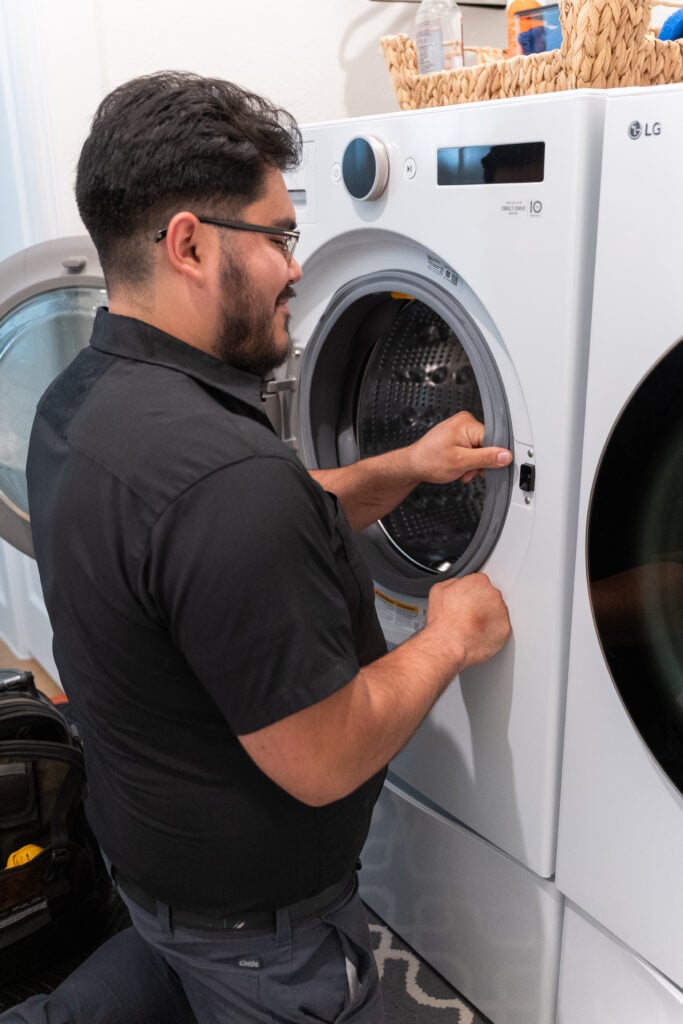 Technician repairing a front-load washer